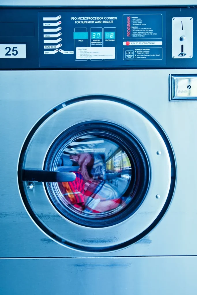 Laundromat washer door with clothes inside the drum